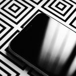 upper part of a black smartphone screen on a black and white squared background